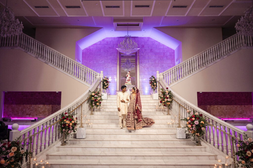 Bride & Groom pose on the grand stairwell of the grand ballroom at the Bellevue