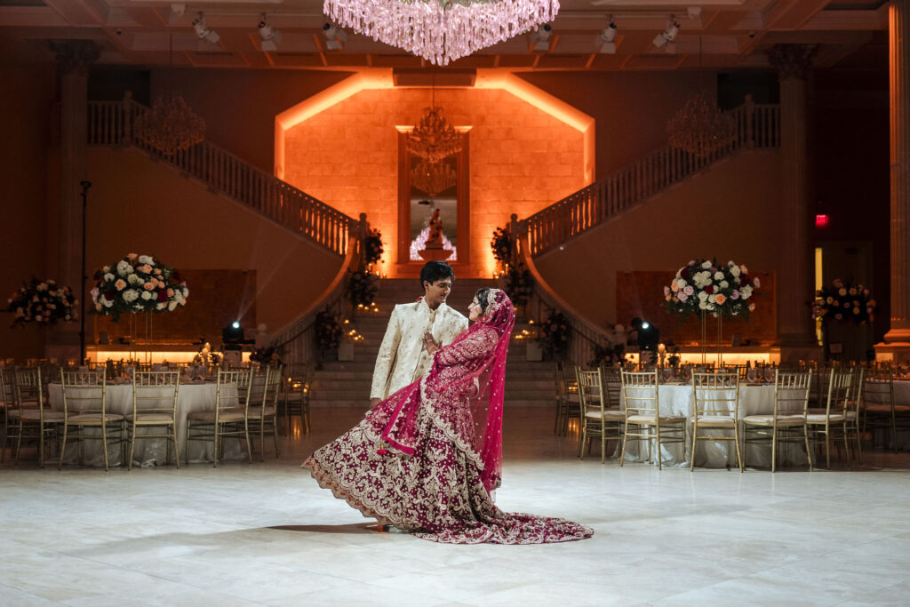 Bride and Groom posing for a dip portrait in the middle of the grand ballroom of the Bellevue Event center in Chantilly, VA